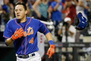 New York Mets' Wilmer Flores (4) tosses his helmet aside as he heads for home after hitting a walk off solo home run during the twelfth inning of a baseball game to beat the Washington Nationals 2-1, Friday, July 31, 2015, in New York. (AP Photo/Julie Jacobson)
